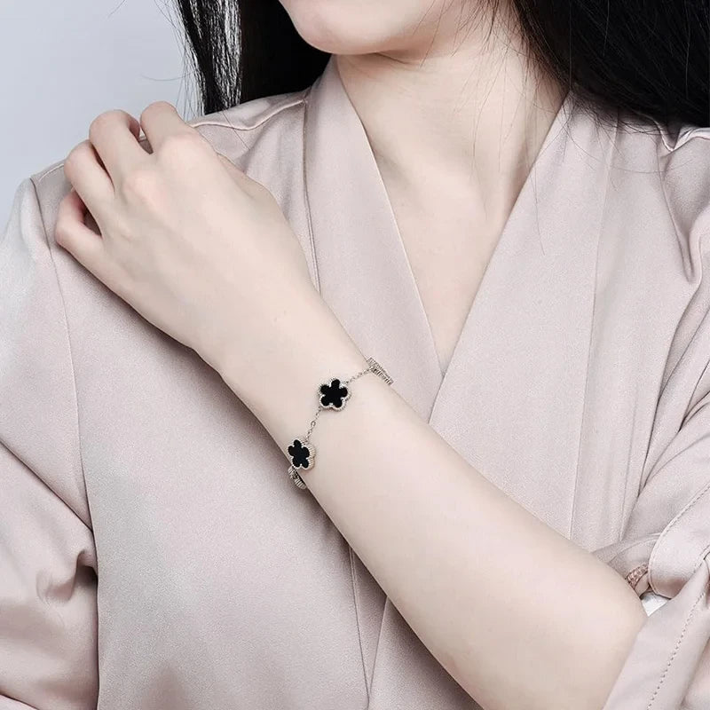 Double Sided Clover Charm Bracelet worn on a woman's wrist showcasing its stylish clover design.