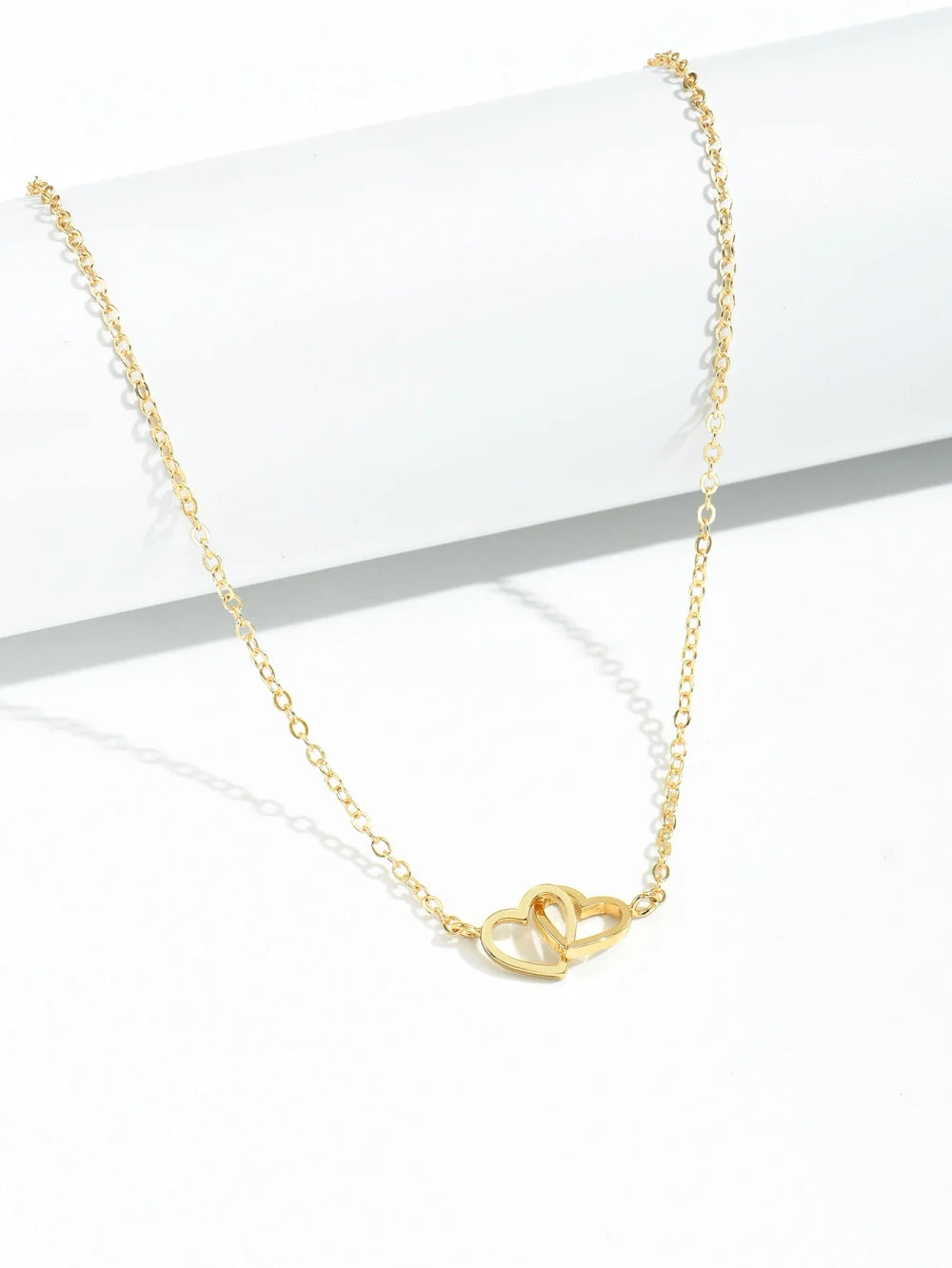 Double Hollow Heart Chain Necklace featuring a delicate double hollow heart design on a gold chain.