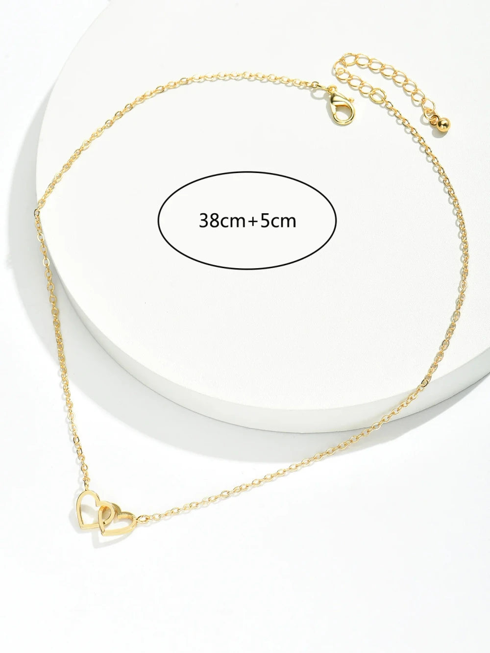 Double Hollow Heart Chain Necklace on a display with a length indication of 38cm+5cm.